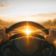 Silhouette of hands holding a steering wheel with sunlight shining